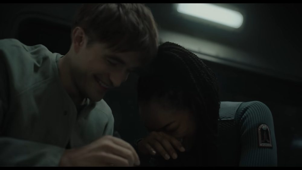 man and woman with long braids smile together.